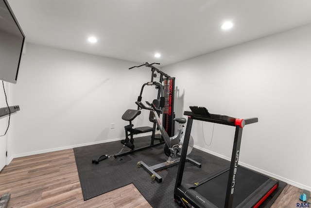 workout area featuring recessed lighting, baseboards, and wood finished floors