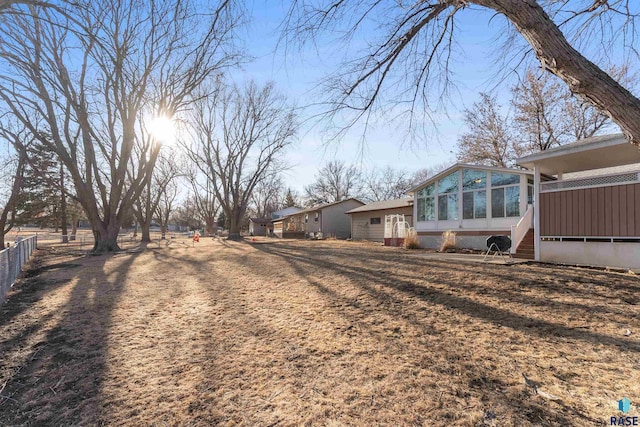 view of yard with fence and a sunroom