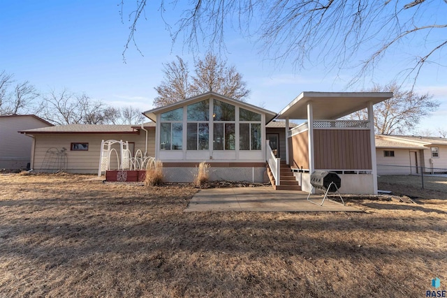 view of front of property with fence and a sunroom