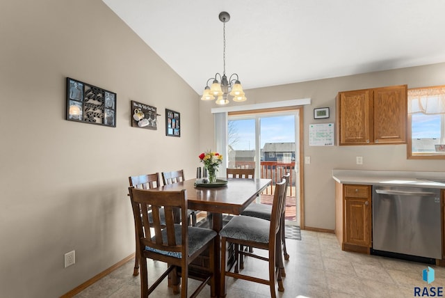 dining area with baseboards, a notable chandelier, and vaulted ceiling