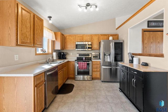 kitchen with a toaster, light countertops, vaulted ceiling, stainless steel appliances, and a sink