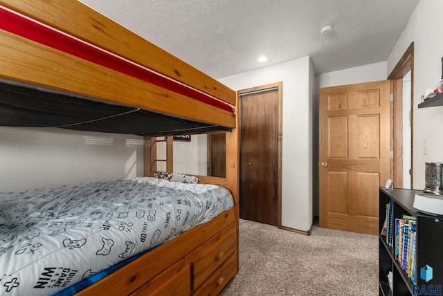 bedroom with carpet flooring, a closet, and a textured ceiling