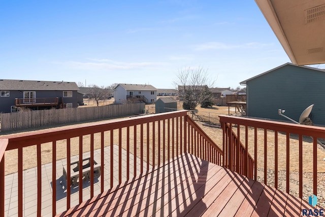 wooden terrace with a residential view and fence