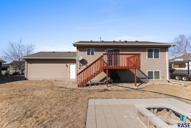 rear view of house featuring a deck, stairway, and fence