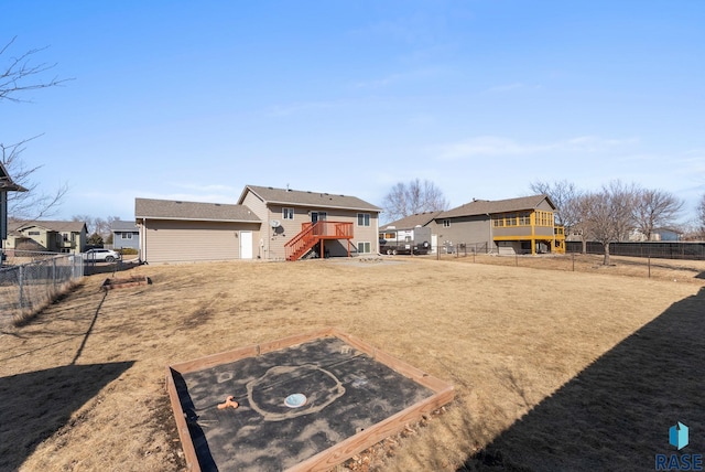 view of yard featuring a deck, a residential view, stairs, and a fenced backyard