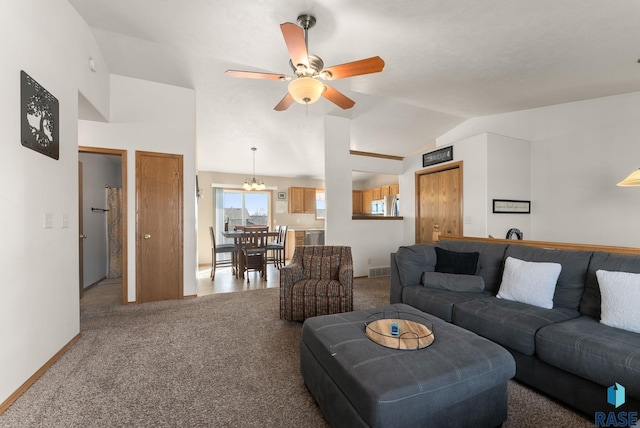 living room featuring visible vents, baseboards, carpet, vaulted ceiling, and ceiling fan with notable chandelier