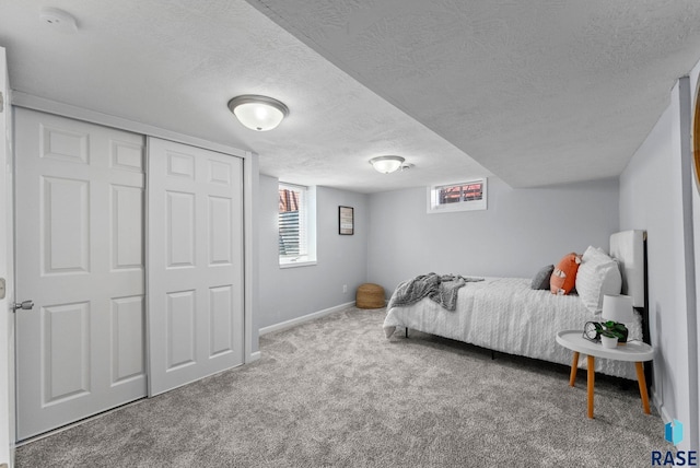 carpeted bedroom featuring baseboards and a textured ceiling