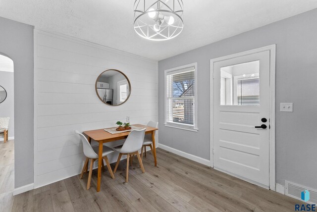 dining space featuring a notable chandelier, visible vents, baseboards, and wood finished floors