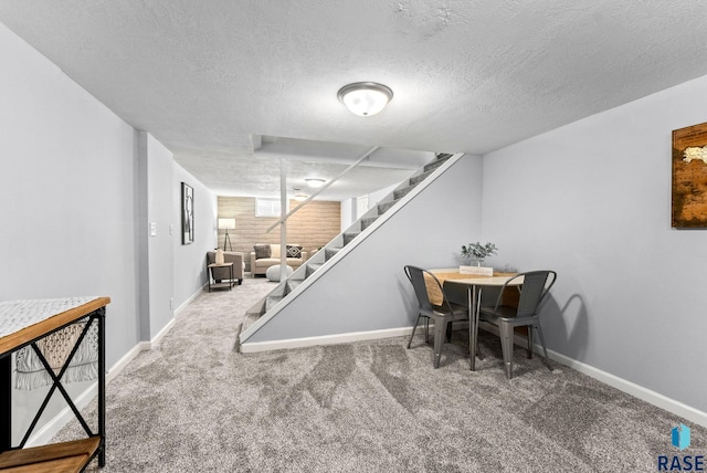 carpeted dining area with baseboards, a textured ceiling, and stairs