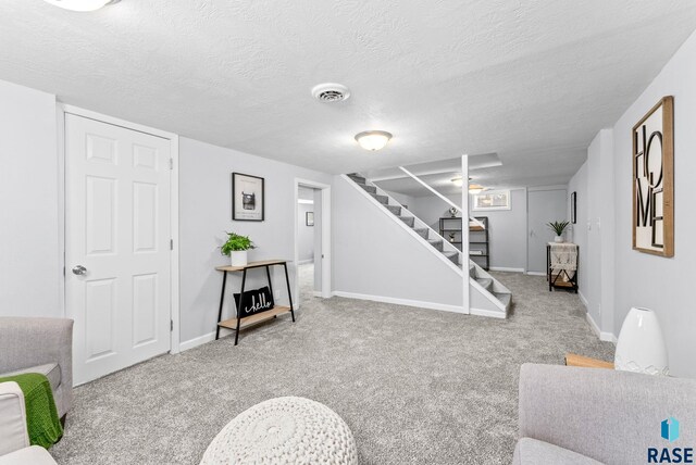 living room with carpet flooring, baseboards, stairs, and visible vents