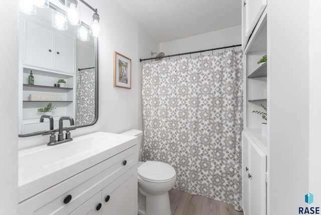 bathroom with toilet, vanity, a shower with curtain, and wood finished floors