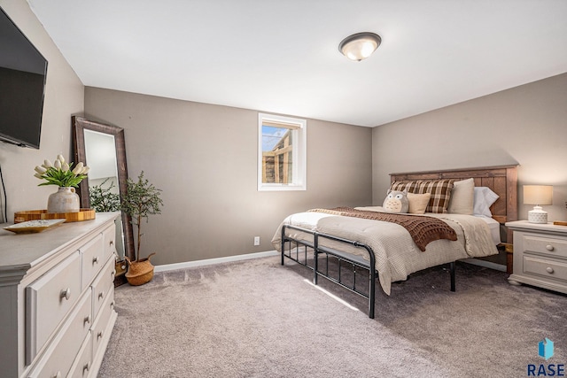 bedroom with light colored carpet and baseboards