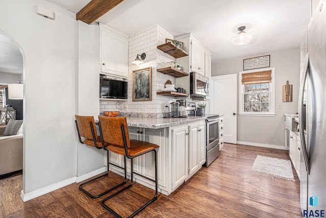 kitchen with open shelves, backsplash, white cabinetry, stainless steel appliances, and arched walkways