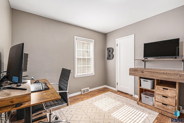 office with visible vents, baseboards, and wood finished floors