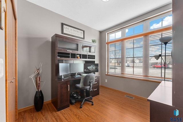 home office featuring wood finished floors, visible vents, and baseboards