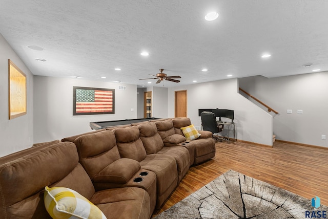 living room featuring recessed lighting, light wood-style floors, and a textured ceiling