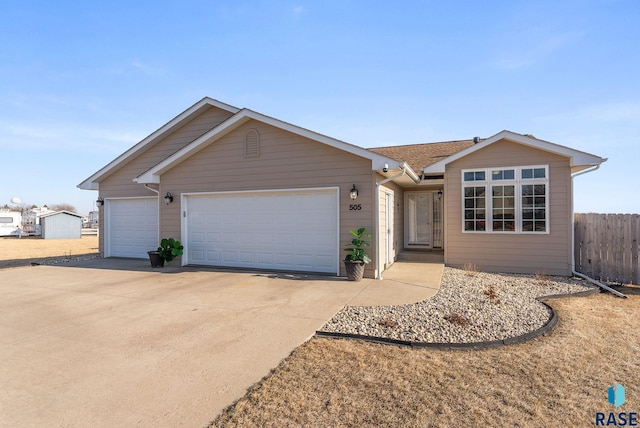 ranch-style home featuring an attached garage, fence, and driveway