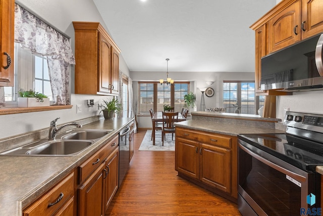 kitchen featuring dark wood-style floors, brown cabinets, appliances with stainless steel finishes, and a sink