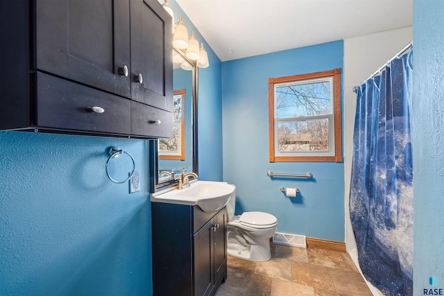 bathroom with visible vents, baseboards, toilet, stone tile floors, and vanity