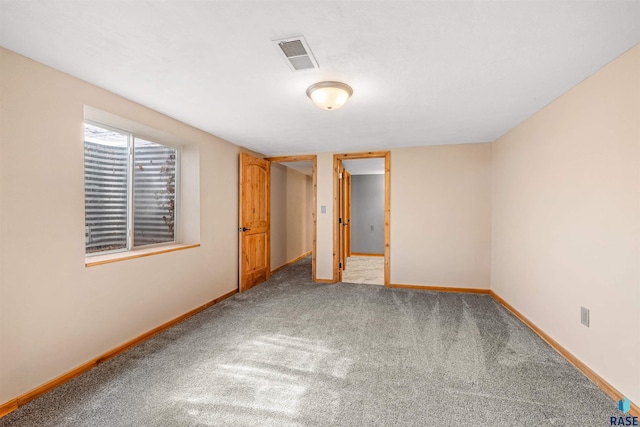 unfurnished room with visible vents, baseboards, and carpet flooring