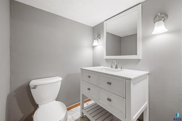 half bathroom with baseboards, toilet, and vanity