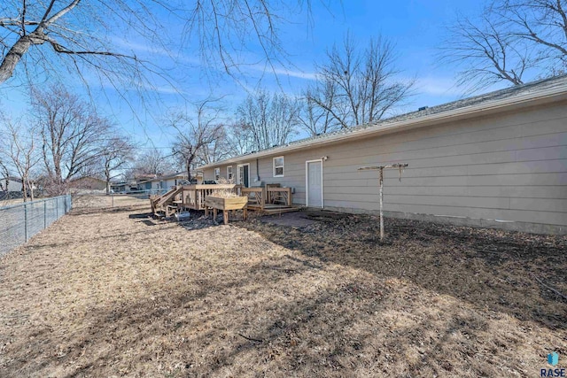 back of property with a fenced backyard and a deck