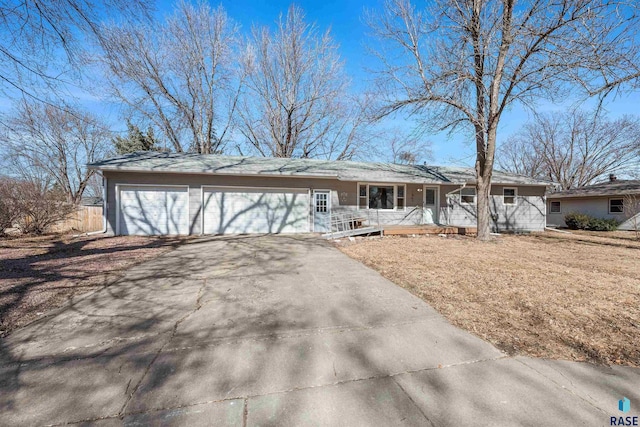 ranch-style house featuring aphalt driveway, a garage, and covered porch