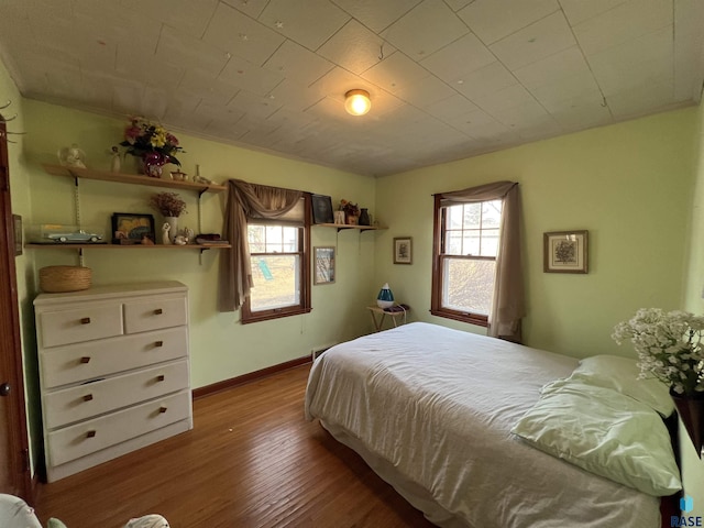 bedroom with baseboards and wood finished floors