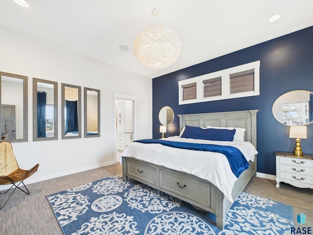 bedroom with an inviting chandelier, wood finished floors, and baseboards