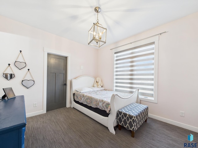 carpeted bedroom featuring a notable chandelier and baseboards