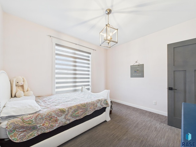 carpeted bedroom featuring baseboards and a notable chandelier