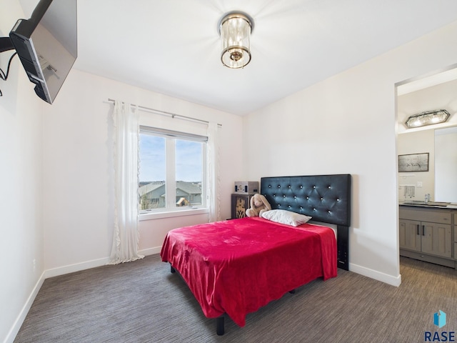 bedroom featuring connected bathroom, baseboards, and carpet flooring