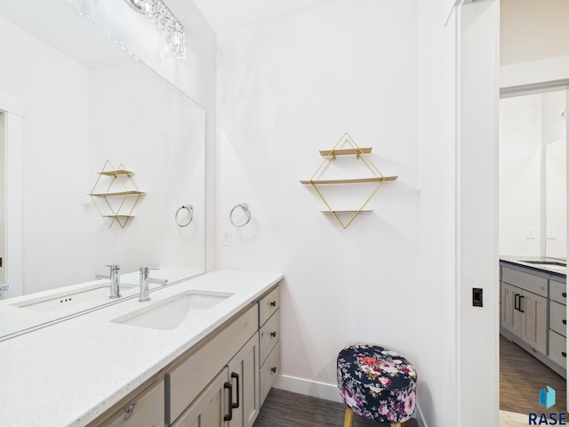 bathroom with vanity, baseboards, and wood finished floors