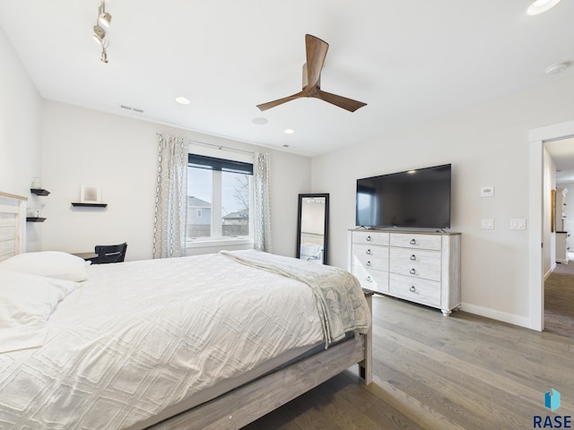 bedroom featuring a ceiling fan, wood finished floors, visible vents, baseboards, and recessed lighting