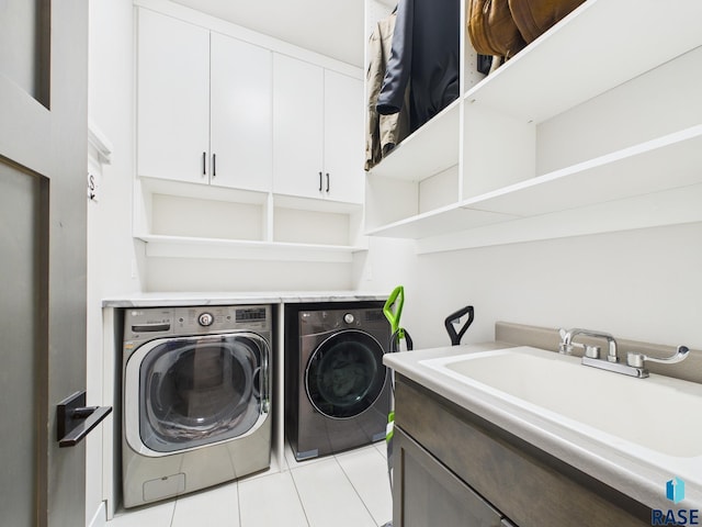 washroom featuring a sink, cabinet space, independent washer and dryer, and light tile patterned floors