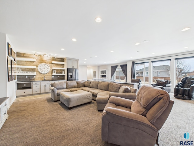 living area featuring recessed lighting and light colored carpet