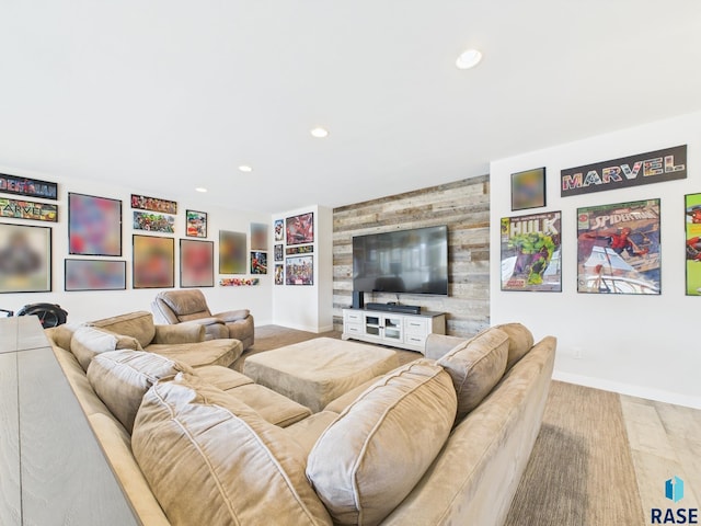 living area featuring an accent wall, wooden walls, recessed lighting, and baseboards