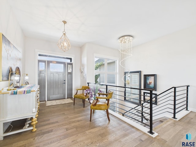 entrance foyer with wood finished floors and a chandelier