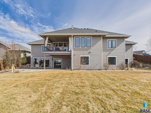 back of property with a patio, a balcony, a lawn, and fence