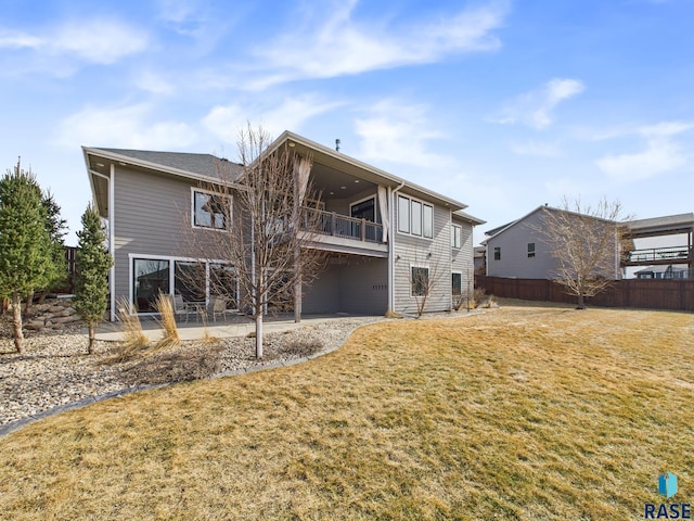 back of house featuring a patio, a lawn, and fence