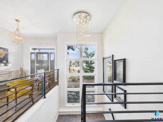 interior space with a notable chandelier, baseboards, and wood finished floors