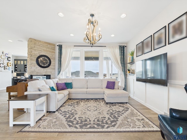 living area with recessed lighting, baseboards, a notable chandelier, and wood finished floors