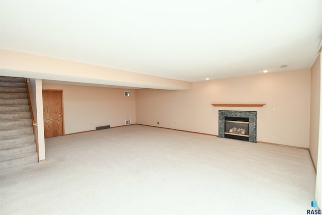 finished basement with visible vents, stairway, baseboards, and carpet