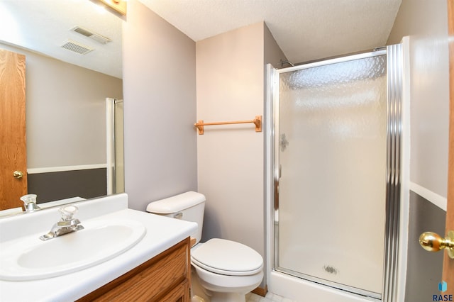 bathroom featuring visible vents, a shower stall, toilet, vanity, and a textured ceiling