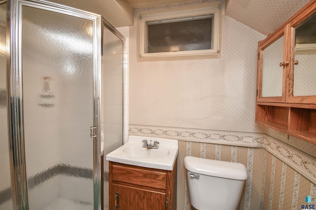 full bathroom with vanity, toilet, a shower stall, and wallpapered walls