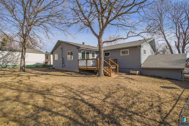 back of house featuring a lawn, roof with shingles, and a wooden deck