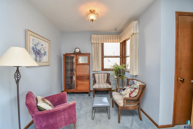 sitting room featuring carpet and baseboards