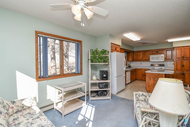 kitchen featuring a center island, light countertops, decorative backsplash, brown cabinets, and white appliances