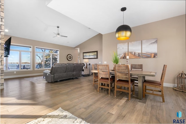 dining room featuring a ceiling fan, lofted ceiling, wood finished floors, and baseboards