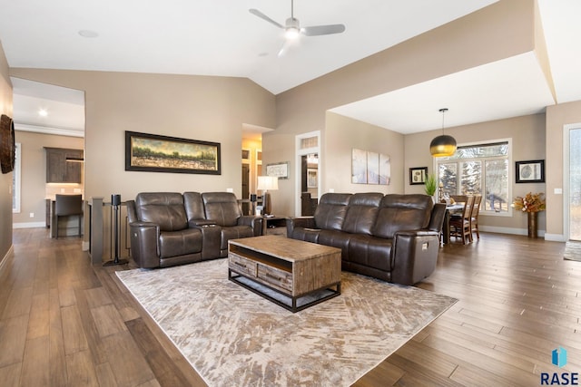 living area with ceiling fan, baseboards, lofted ceiling, and dark wood-style floors